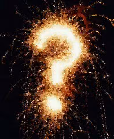 A bright, fiery question mark formed by bursts of fireworks illuminating a dark night sky.