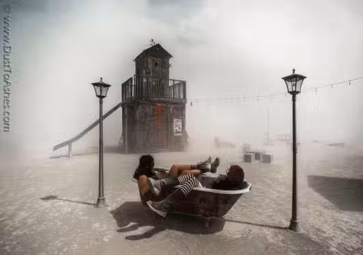 Two people relax in a bathtub on a barren, dusty landscape reminiscent of a Colorado burner setting. Nearby, a whimsical wooden structure with a slide complements the scene, as string lights hang between lampposts enveloped in fog or dust—evoking the spirit of Burning Man art.