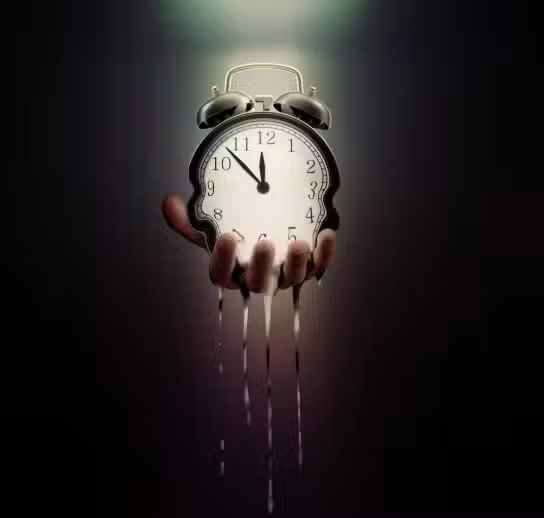 A hand holds a classic alarm clock that is melting and dripping like liquid, symbolizing the passage or distortion of time, against a dark, moody background.