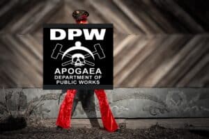 A person in red pants and a black hat stands against a rustic wood wall, holding a large black-and-white sign reading “DPW APOGAEA DEPARTMENT of PUBLIC WORKS” with crossed hammers and a skull logo.